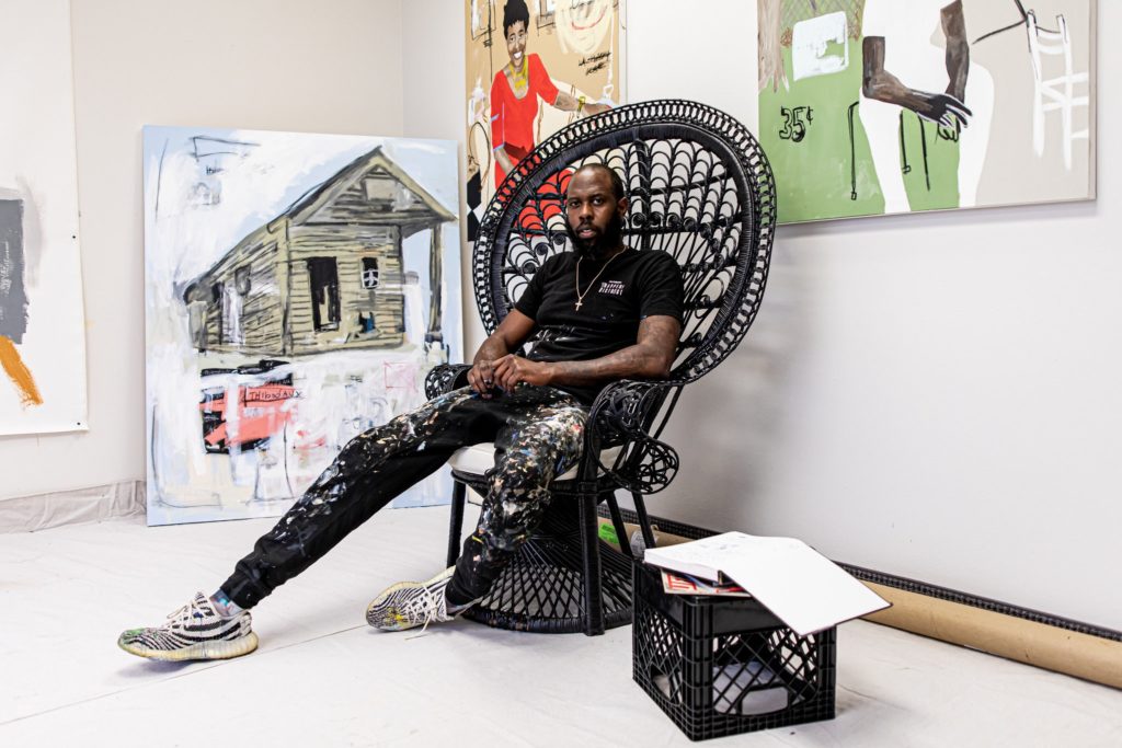 Jammie Holmes in his studio in Dallas with works Box Fan Heroes (2019) and Mama Raised Me (2020). Photo by Emery Davis, courtesy of the Library Street Collective, Detroit.