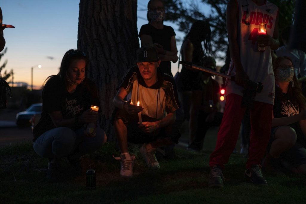 Moniqa Estrada and John Anthony Lopez attend a candlelight vigil in Tiguex Park for Scott Williams, who was shot and seriously injured by counter protester Steven Baca during a protest to remove a sculpture of conquistador Juan de Oñate at the Albuquerque Museum on June 16, 2020 in Albuquerque, New Mexico. Photo by Paul Ratje/AFP via Getty Images.