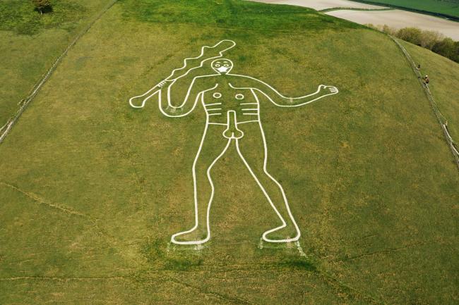 The hill figure Cerne Abbas in Dorset, England, outfitted with a face mask. Photo by Kevin Knight. 