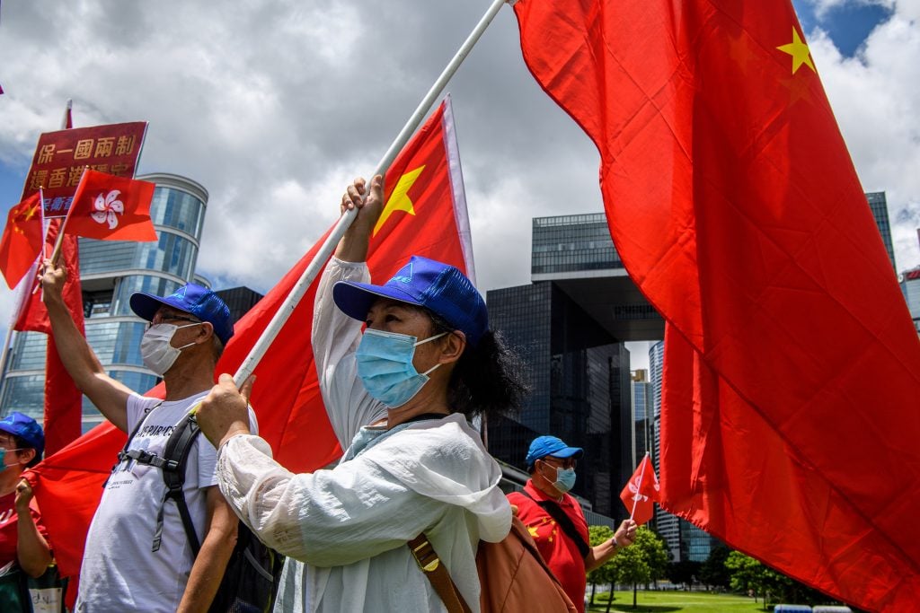 Pro-China supporters display Chinese and Hong Kong flags during a rally near the government headquarters in Hong Kong on June 30, 2020, as China passed a sweeping national security law for the city. (Photo by ANTHONY WALLACE/AFP via Getty Images)