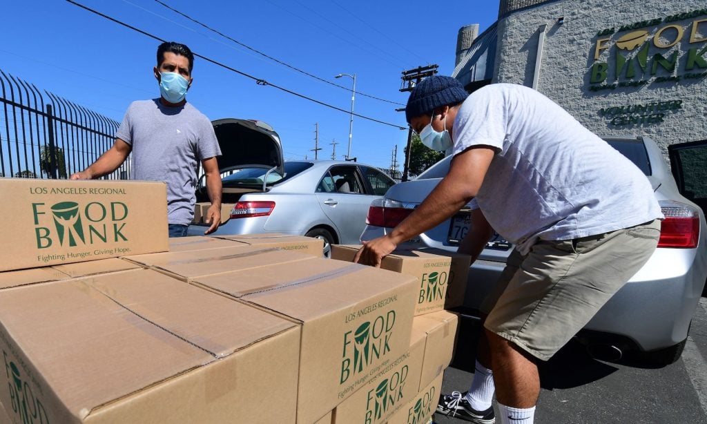 People load their vehicles with boxes of food at a Los Angeles Regional Food Bank on May 5, 2020 in Los Angeles, California. Photo by Frederic J. Brown/ AFP via Getty Images.