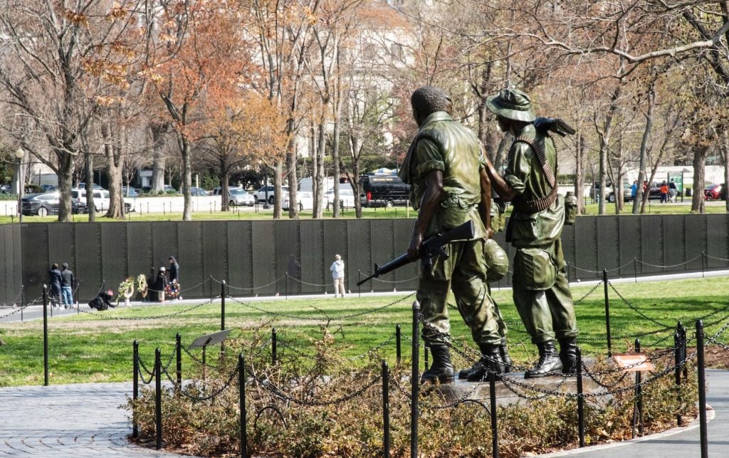 Statue of three armed soldiers at the Vietnam Memorial on the National Mall, Washington, D.C. Photo by Robert Knopes/Education Images/Universal Images Group via Getty Images.