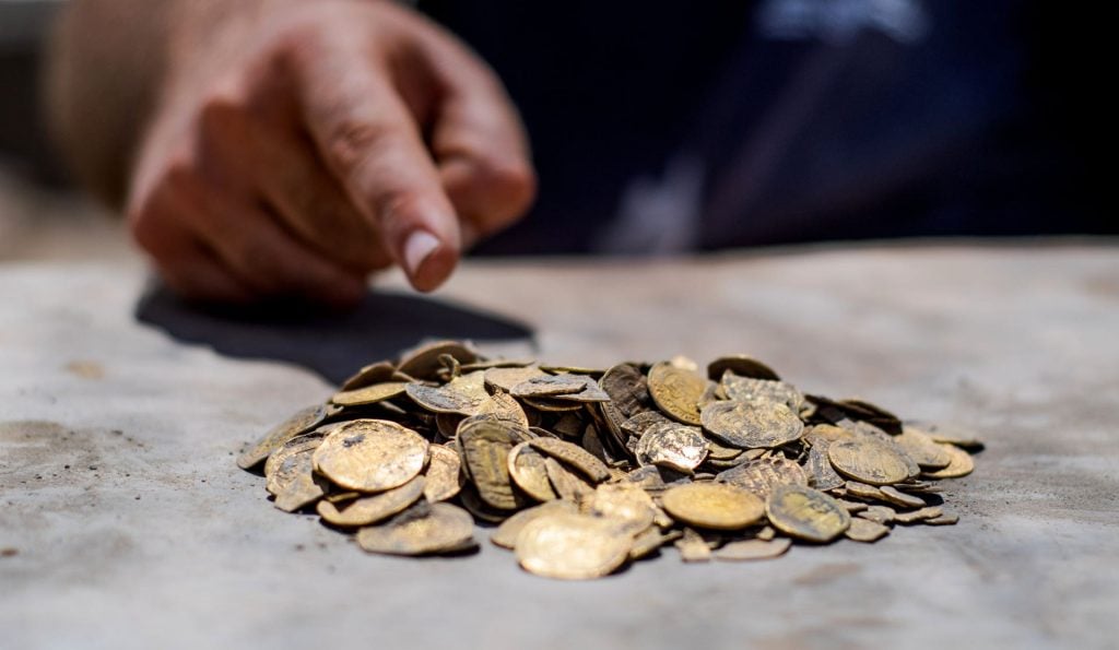 A cache of ancient golden coins was found buried in a clay jar in Israel. Photo by Yoli Shwartz, courtesy of the Israel Antiquities Authority.