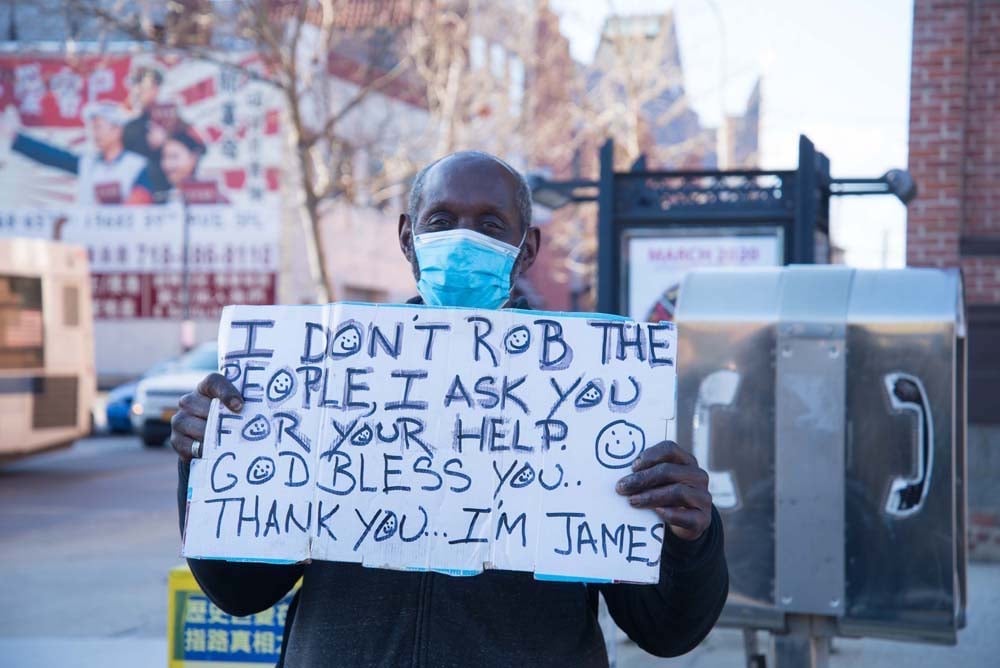 In Queens, a man asks people and cars that pass by for financial help. Photo credit: Kay Hickman