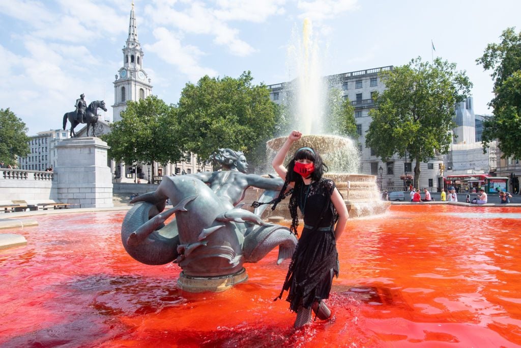 Extinction Rebellion activists dye fountains in Trafalgar Square, London, during a protest in solidarity with indigenous communities in Brazil who are dying from Covid-19. Photo by Dominic Lipinski/PA Images via Getty Images.