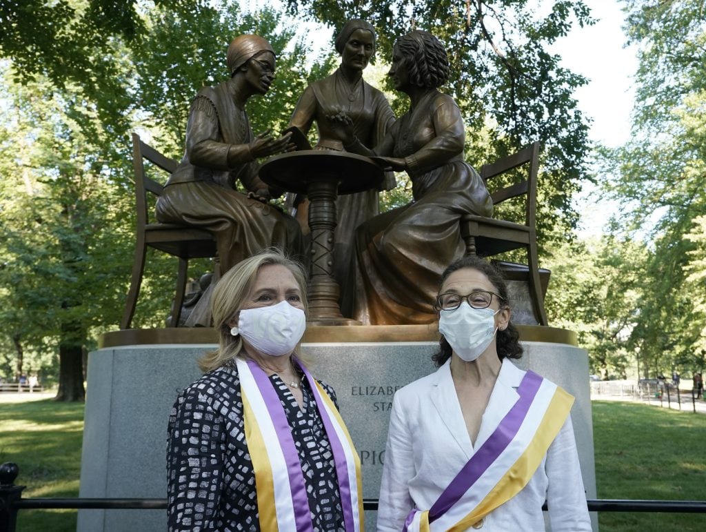 Hillary Clinton poses with sculptor Meredith Bergmann after the unveiling of the statue of women's rights pioneers Susan B. Anthony, Elizabeth Cady Stanton, and Sojourner Truth in central Park in New York on August 26, 2020. It is the park's first statue of real-life women and its first statue of an African American. Photo by Timothy A. Clary/AFP via Getty Images.