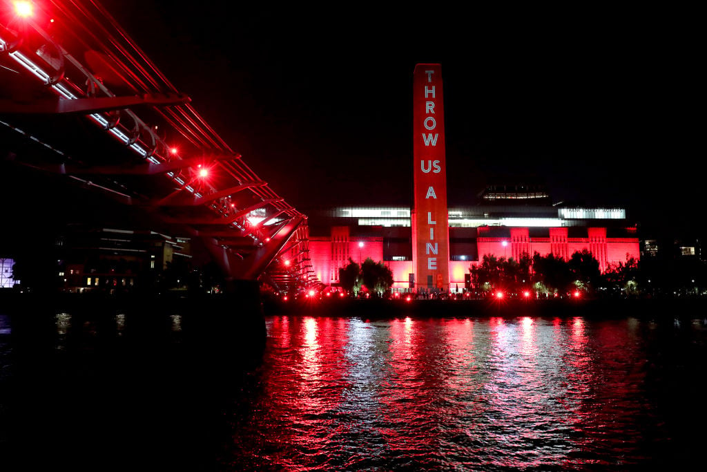 The Tate Modern is lit up in red as supporters also shine red lights from the Millennium Bridge as part of the #WeMakeEvents' 'Throw Us a Line Campaign' supporting on August 11, 2020 in London, England. Photo by Chris Jackson/Getty Images.