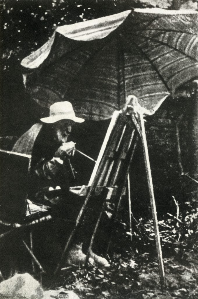 Renoir painting outdoors, circa 1910s, with his right hand. Photo by Print Collector/Getty Images.