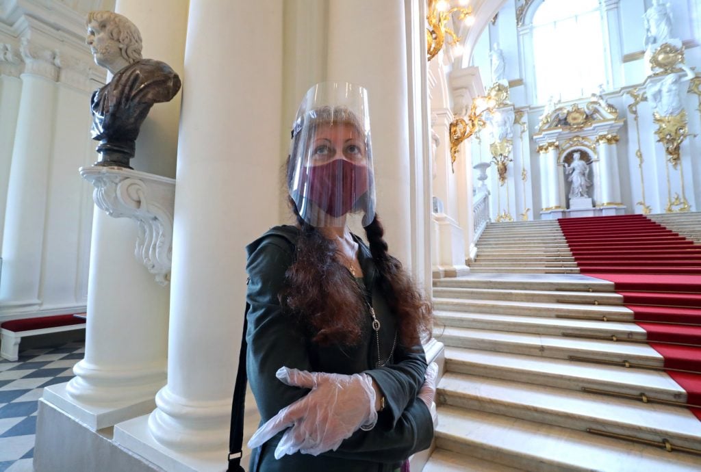 A woman with a face shield on visits the State Hermitage Museum reopening with COVID-19 lockdown restrictions lifted. Peter Kovalev/TASS (Photo by Peter KovalevTASS via Getty Images)