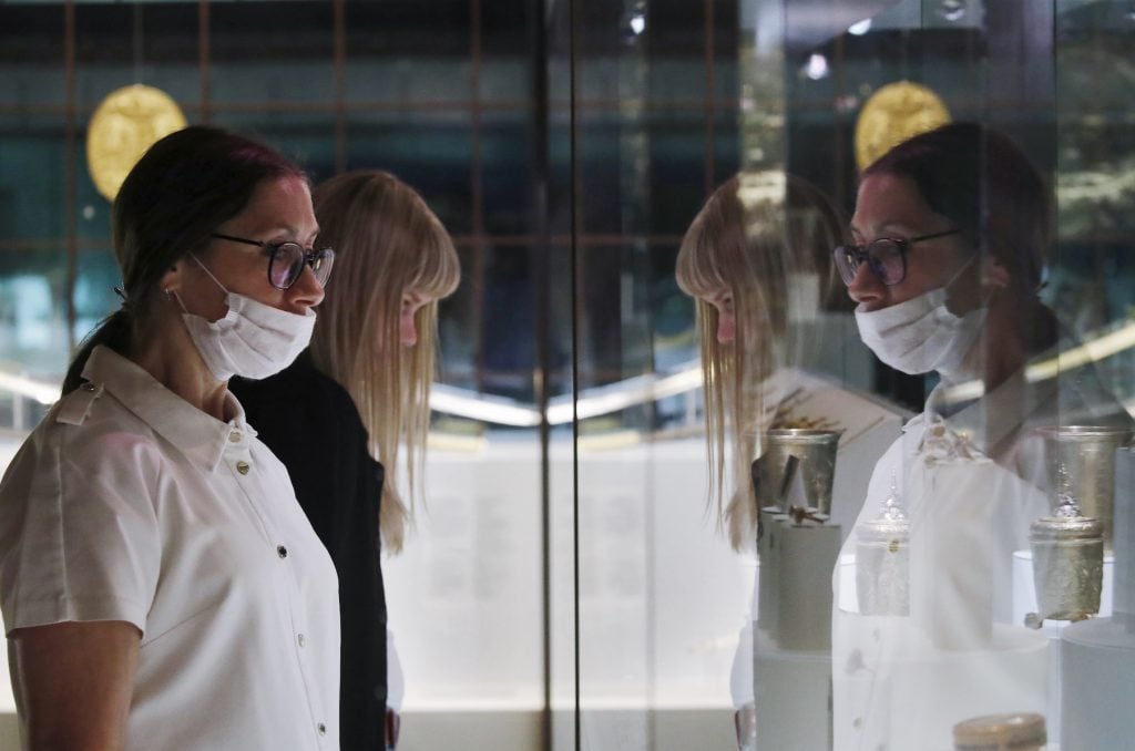 Visitors in face masks view an exhibition in the State Historical Museum in Moscow during the pandemic. (Photo by Artyom Geodakyan/TASS via Getty Images)