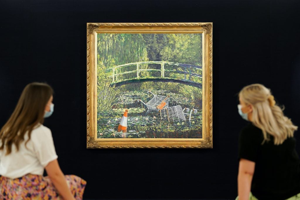 Banksy's Show Me The Monet (2005) inexplicably shown with two women. Courtesy of Sotheby's. Photo: Michael Bowles/Getty Images for Sotheby's.