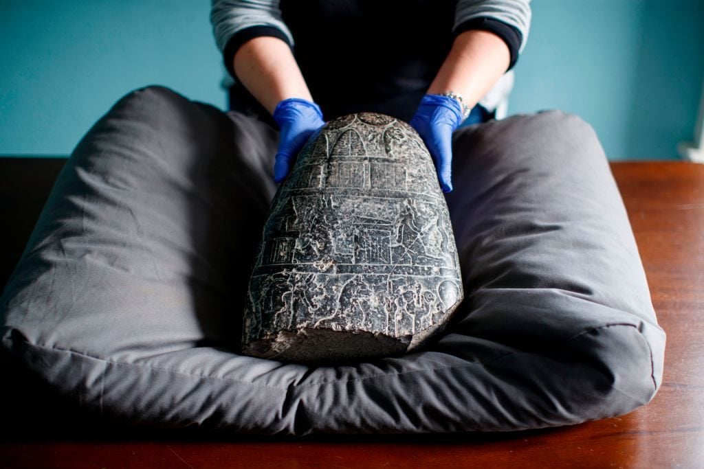 A Babylonian cuneiform kudurru (boundary stone) which was looted from Iraq on March 19, 2019 at the British museum in London. The kudurru was seized at London's Heathrow airport in 2012. Photo by Tolga Akmen/AFP via Getty Images.