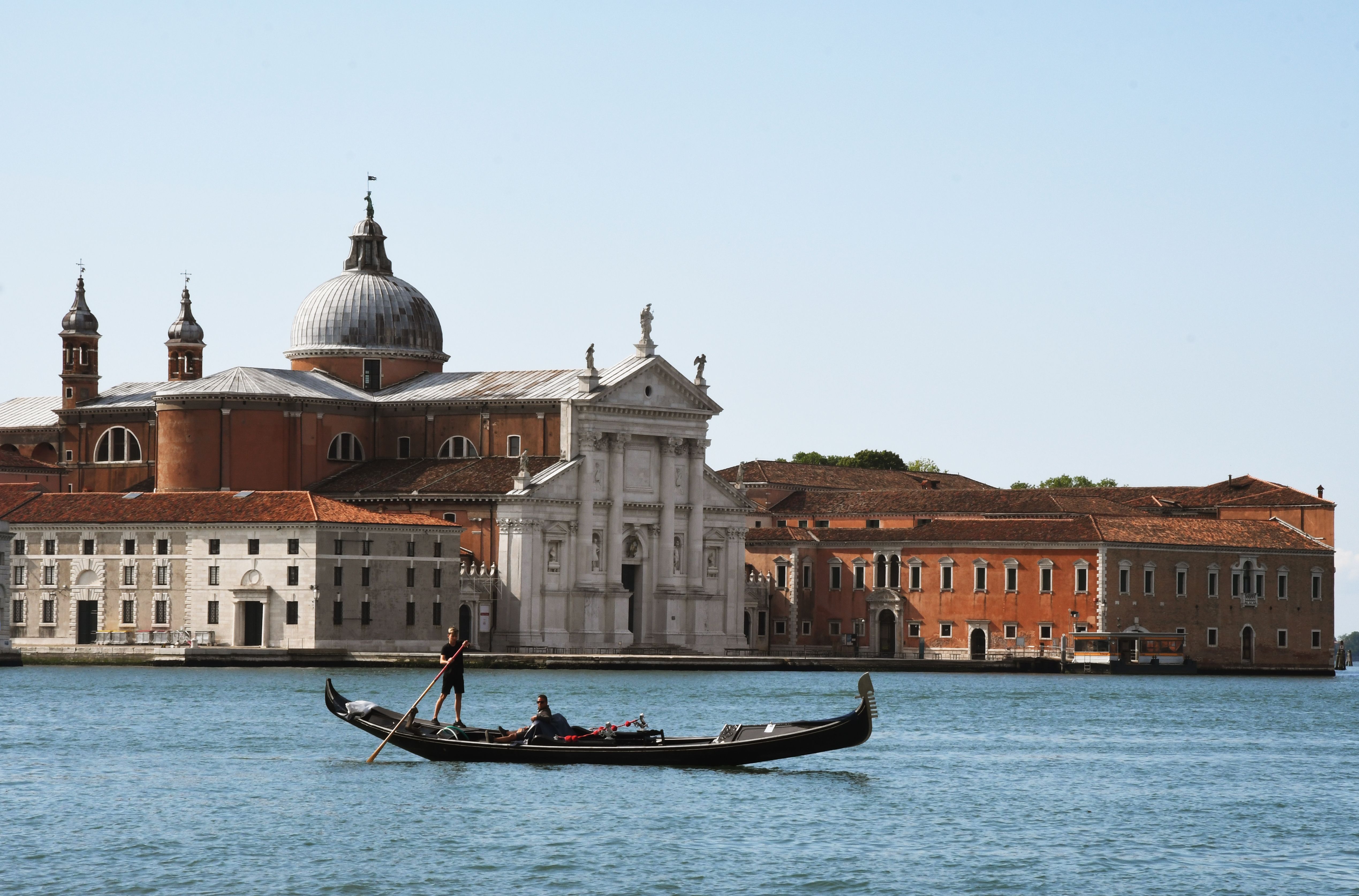 A gondola riding past the church of Saint Giorgio Maggiore on May 30, 2020 in Venice, as the country eases its lockdown. Photo by ANDREA PATTARO/AFP via Getty Images)