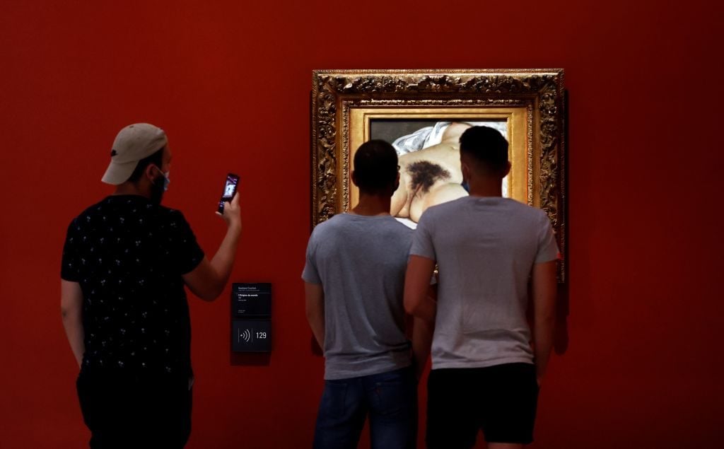 Visitors look at Gustave Courbet' s painting The Origin of the World as they visit the Orsay museum on its reopening day, on June 23, 2020. Photo by THOMAS COEX/AFP via Getty Images.