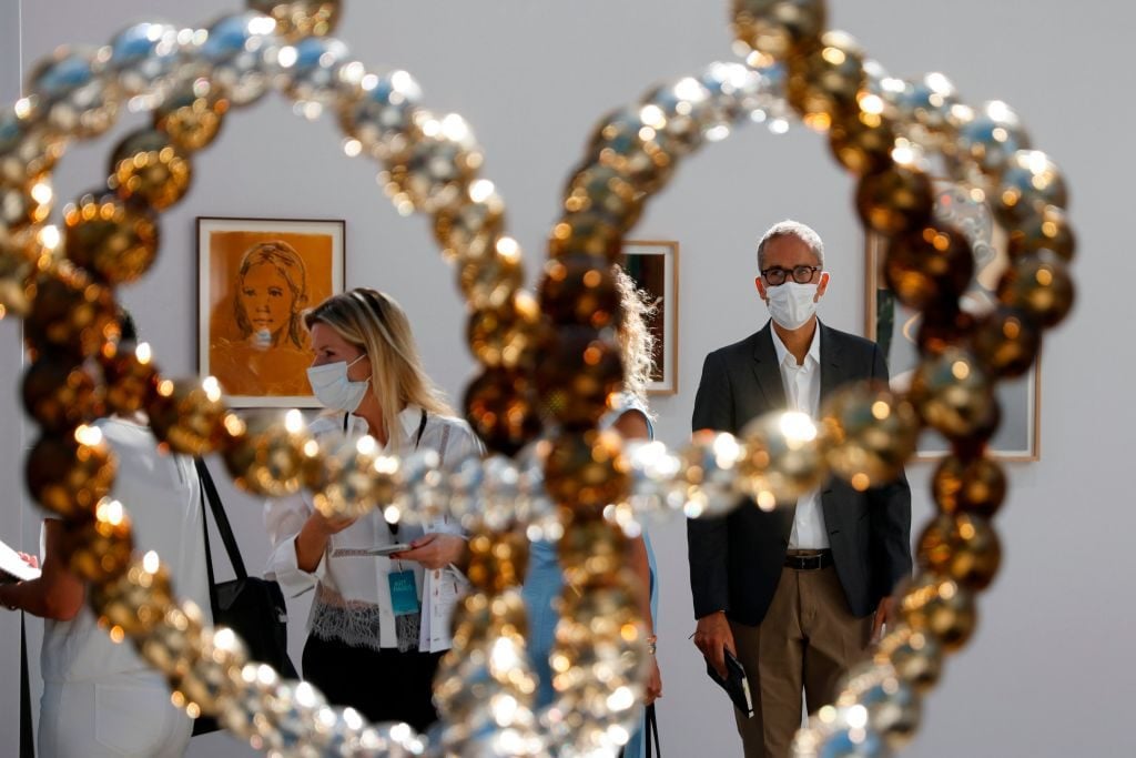 Visitors look at the sculpture 'Noeud Sauvage' by French artist Jean-Michel Othoniel during the preview of the 22nd edition of the Art Paris art fair at the Grand Palais in Paris, on September 9, 2020. Photo by THOMAS SAMSON/AFP via Getty Images.