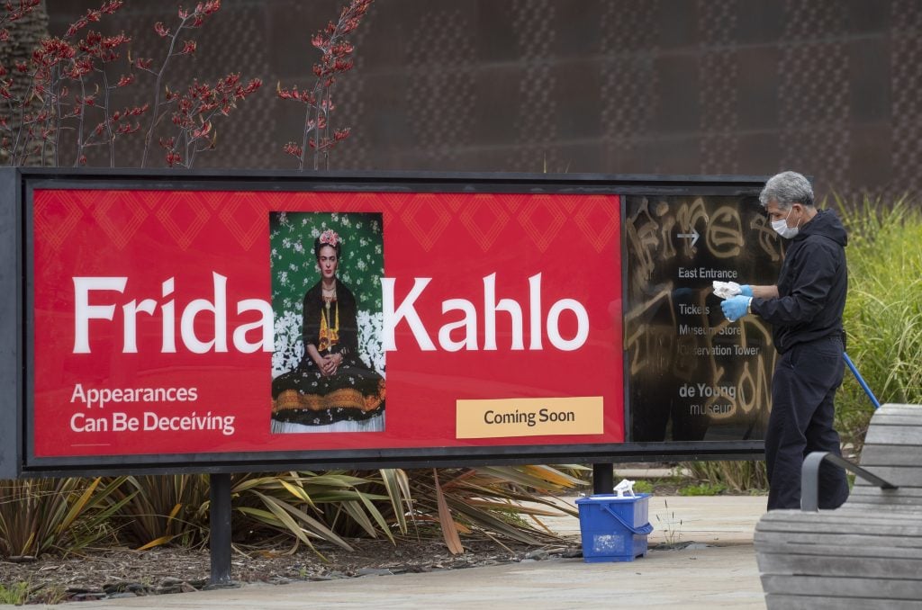 Vandals spray painted a sign for the upcoming Frida Kahlo exhibit at the de Young Museum during a night when nearby statues of Junipero Serra, U.S. Grant, and Francis Scott Key were toppled in San Francisco's Golden Gate Park. Crews worked to mitigate the damage early Saturday morning, June 20, 2020. Photo by Karl Mondon/MediaNews Group/the Mercury News via Getty Images.