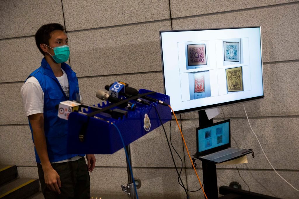 Police show a picture of stolen antique stamps during the press conference in Hong Kong. Photo: Isaac Lawrence/AFP via Getty Images.