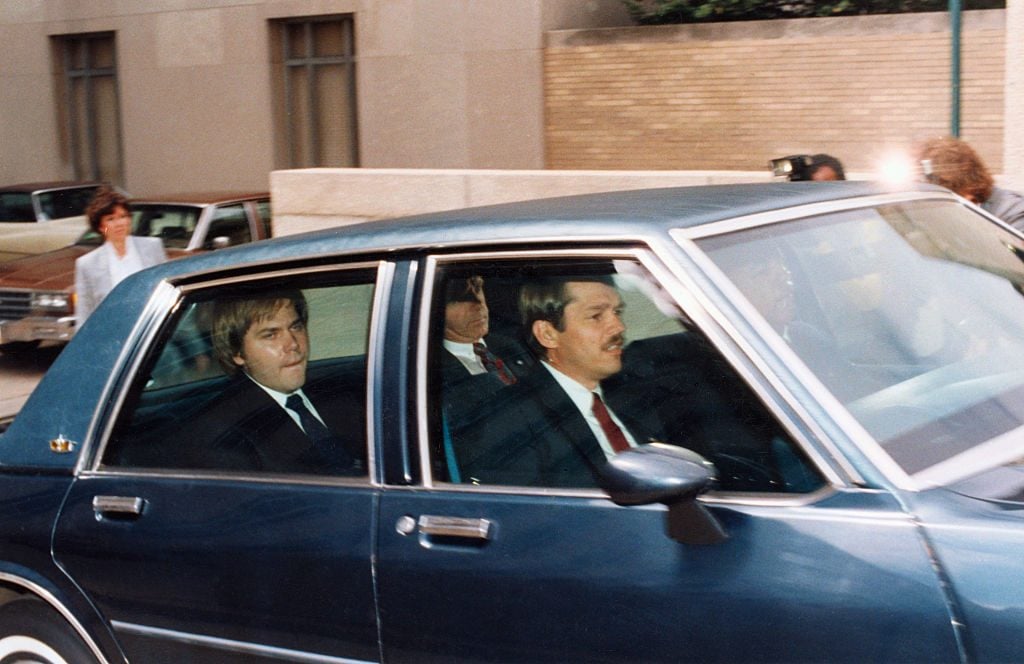 John Hinckley, Jr., in the back of a vehicle outside a federal court in DC. Courtesy of Getty Images.