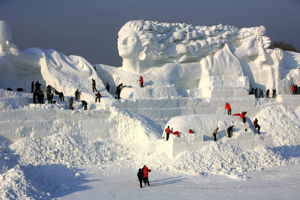 Workers work to make snow sculpture <em>Romantic Feelings</em> at the 20th International Snow Sculpture Art Expo on December 17, 2007 in Harbin of Heilongjiang Province, China. Photo by China Photos/Getty Images.