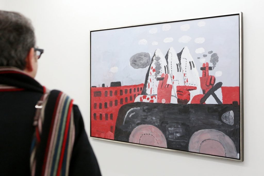 A visitor looks at Philip Guston's <em>Riding Around</em> in the Falkenberg in Hamburg. Photo by Bodo Marks/picture alliance via Getty Images.