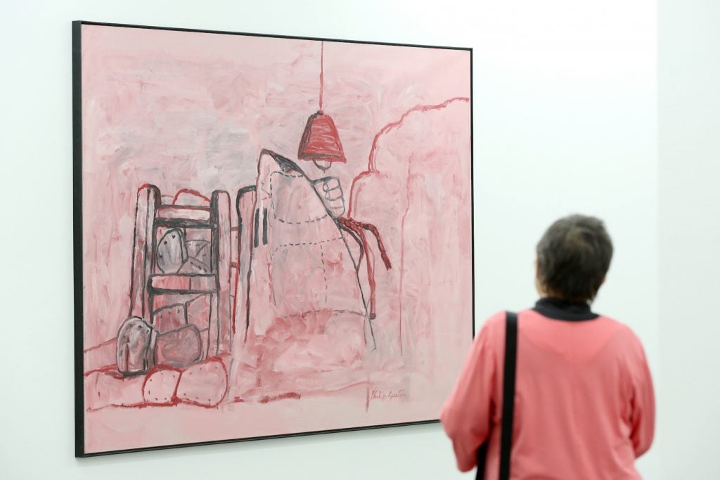 A visitor looks at the work Cave by US painter Philip Guston in the exhibition rooms of the collection Falkenberg in Hamburg, Germany, February 21, 2014. Photo by Bodo Marks/picture alliance via Getty Images.