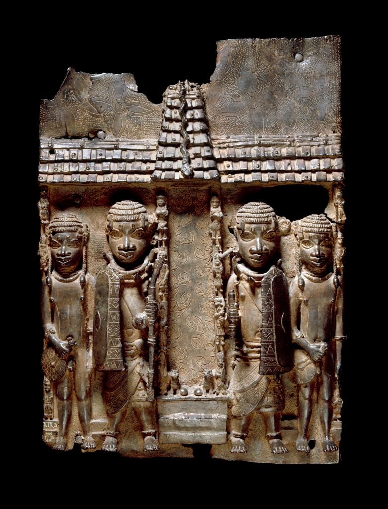 Benin brass plaque (16th- 17th century) showing Benin court officials flanking a palace entrance or altar. 2020 © Trustees of the British Museum.