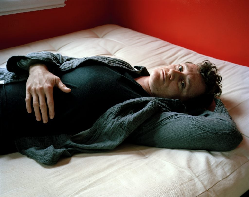 Jess T. Dugan, <i>Dallas lying on the bed</i> (2012). Courtesy of the artist and the Catherine Edelman Gallery, Chicago.