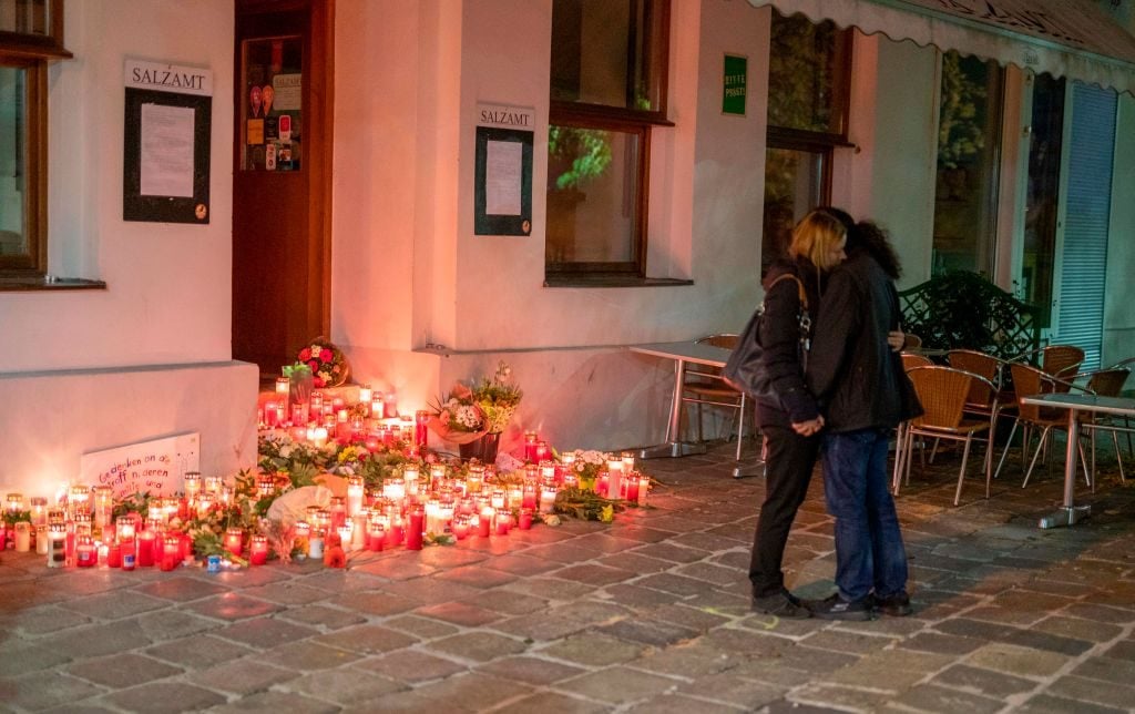 Mourners hugging in front of a restaurant the place of the terrorist attack in Vienna, Austria on November 4, 2020. Photo by JOE KLAMAR/AFP via Getty Images.