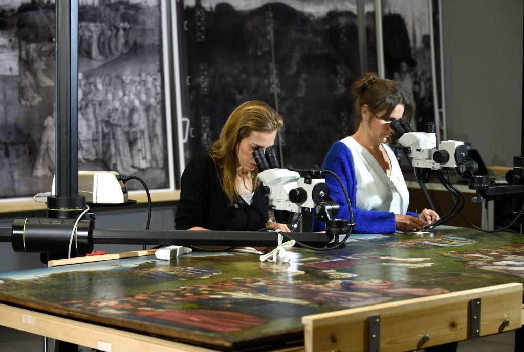 Restorers of the Royal Institute for Cultural Heritage at work on the Ghent Altarpiece. Photo by JOHN THYS / AFP via Getty Images.