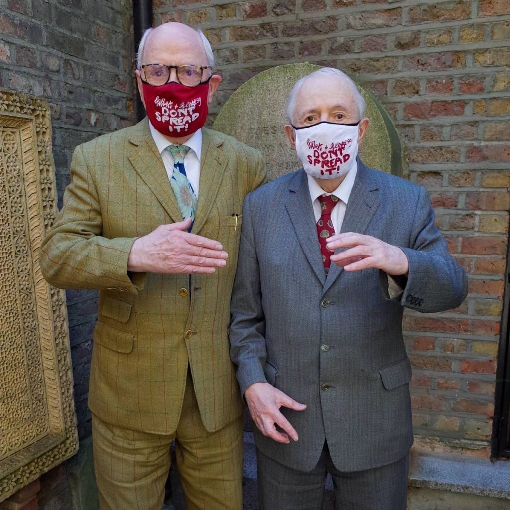 Gilbert & George donning their newly designed masks.