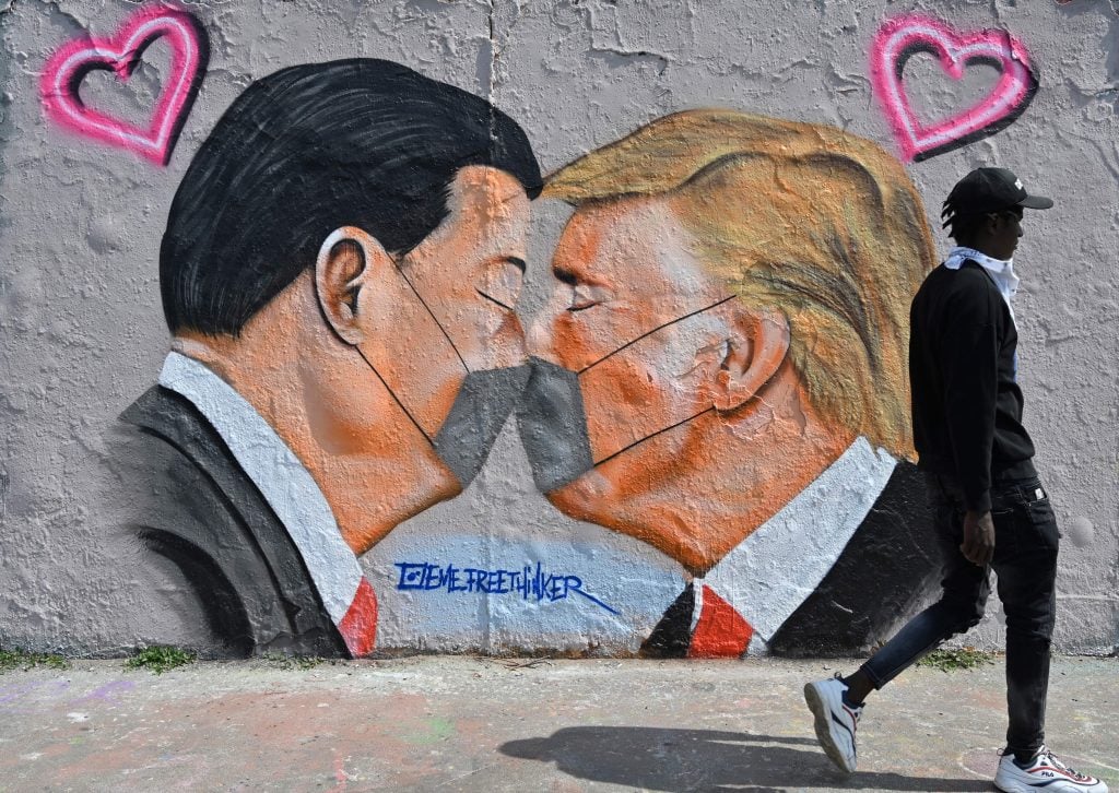 A mural painting by graffiti artist Eme Freethinker features likenesses of US President Donald Trump and Chinese premier Xi Jinping wearing face covers, in Berlin on April 28, 2020. Photo by John MacDougall/AFP via Getty Images.