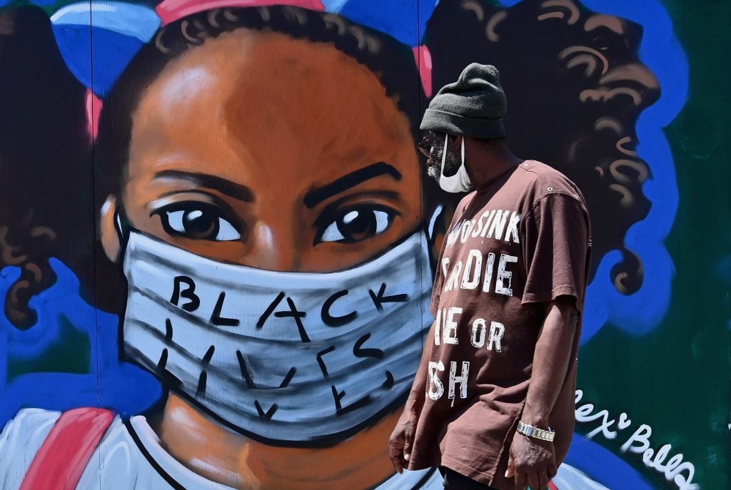 A person walks past a street mural by artist Lexi Bella on June 16, 2020 in Brooklyn. Photo by Angela Weiss/AFP via Getty Images.