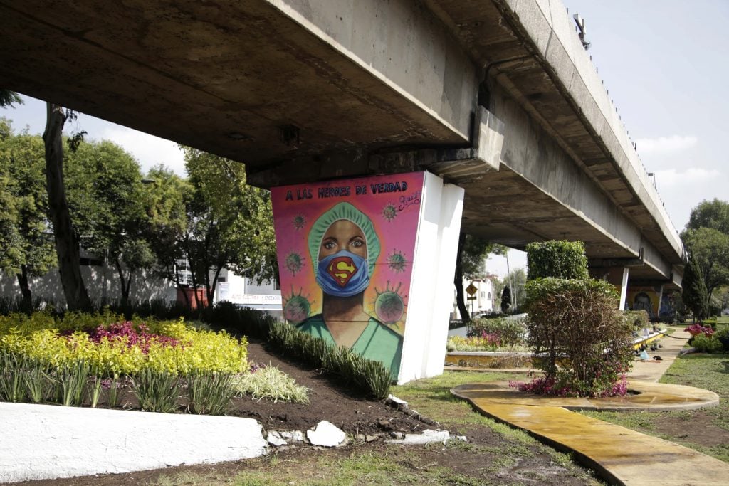 An urban artist painted a mural under a bridge to honor health workers who have given their lives to curb COVID-19 in Mexico City. Photo by Leonardo Casas/Eyepix Group/Barcroft Studios/Future Publishing via Getty Images.