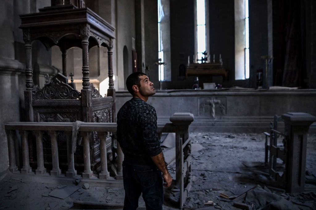 A man looks on as he stands in the rubble and debris on October 8, 2020 inside the damaged Ghazanchetsots (Holy Saviour) Cathedral in the historic city of Shusha or Shushi. Photo: Aris Messinis/AFP via Getty Images.