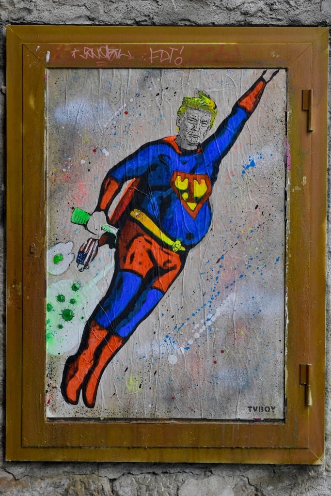 A new artwork by street artist TVBoy depicting US President Donald Trump dressed up in a Superman costume and flying through COVID-19 clouds is pictured in a street in Barcelona on October 8, 2020. Photo by Pau Barrena/AFP via Getty Images.