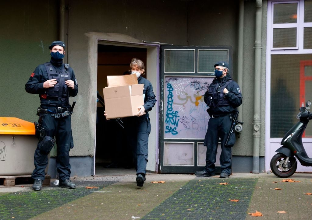 A policewoman carries box with evidence during raids of properties on November 17, 2020 in connection with the heist on Green Vault museum. Photo by Odd Andersen/AFP via Getty Images.