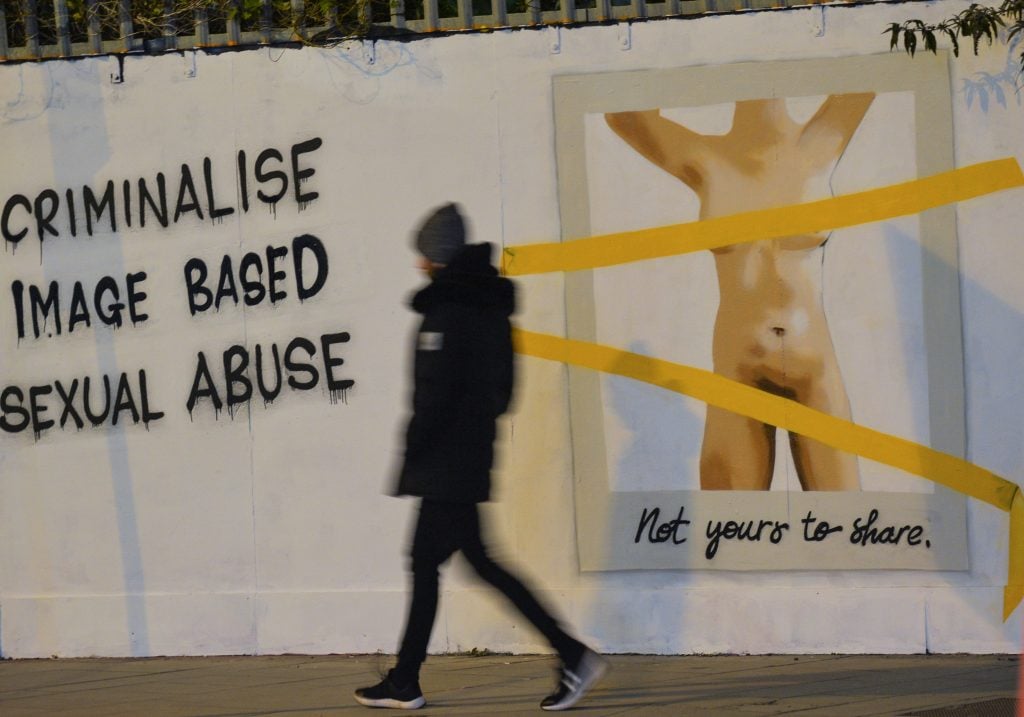 Irish artist Emmalene Blake working on her latest mural, located in Dublin's city center, in response to legislation outlawing so-called "revenge porn," which is sexual abuse based on images, and which is still not a crime in Ireland. Photo by Artur Widak/NurPhoto via Getty Images.