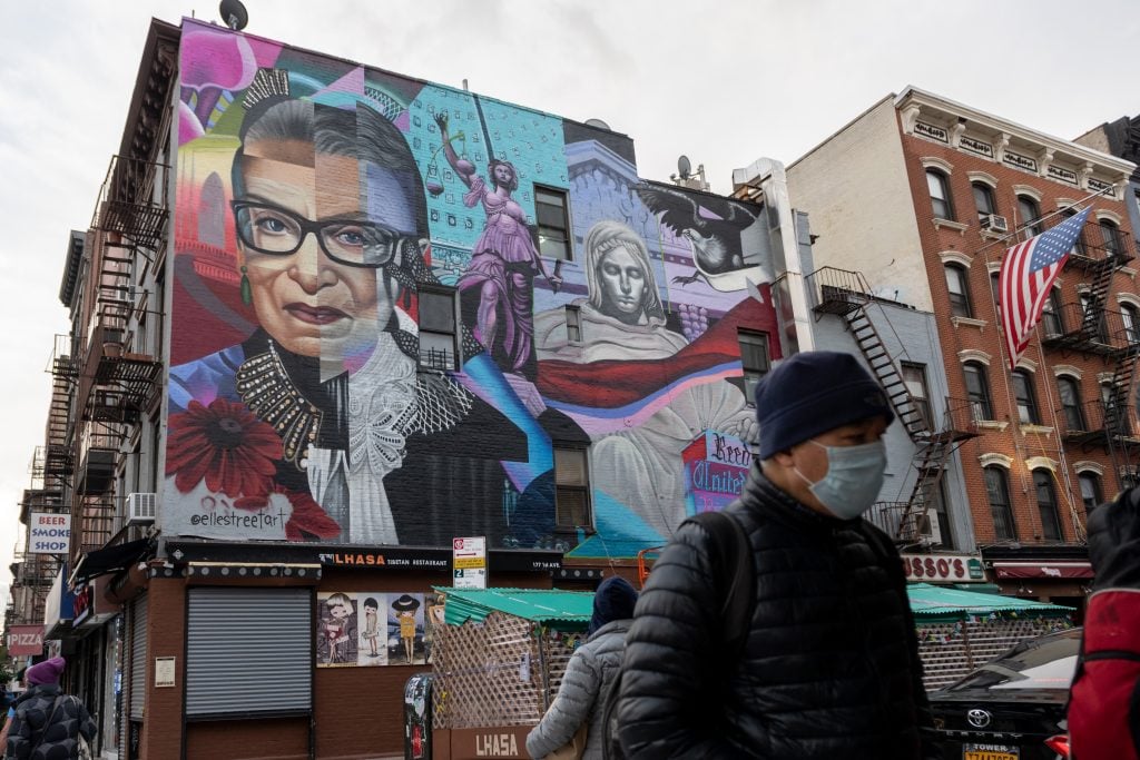 A man wearing a mask walks past a new mural by Elle Street Art of the late Supreme Court Justice Ruth Bader Ginsburg (RBG) commissioned by the Lisa Project on November 17, 2020 in New York City. Photo by Alexi Rosenfeld/Getty Images.