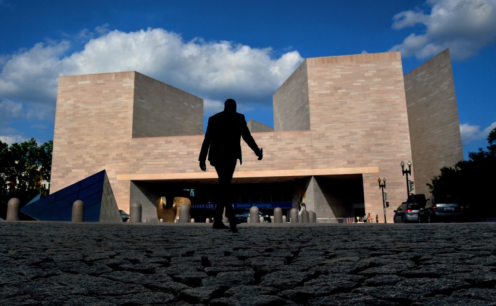 A man makes his way toward the east building of the National Gallery of Art via a cobblestone walkway on a warm and humid day on July 9, 2019. (Photo by Michael S. Williamson/The Washington Post via Getty Images)