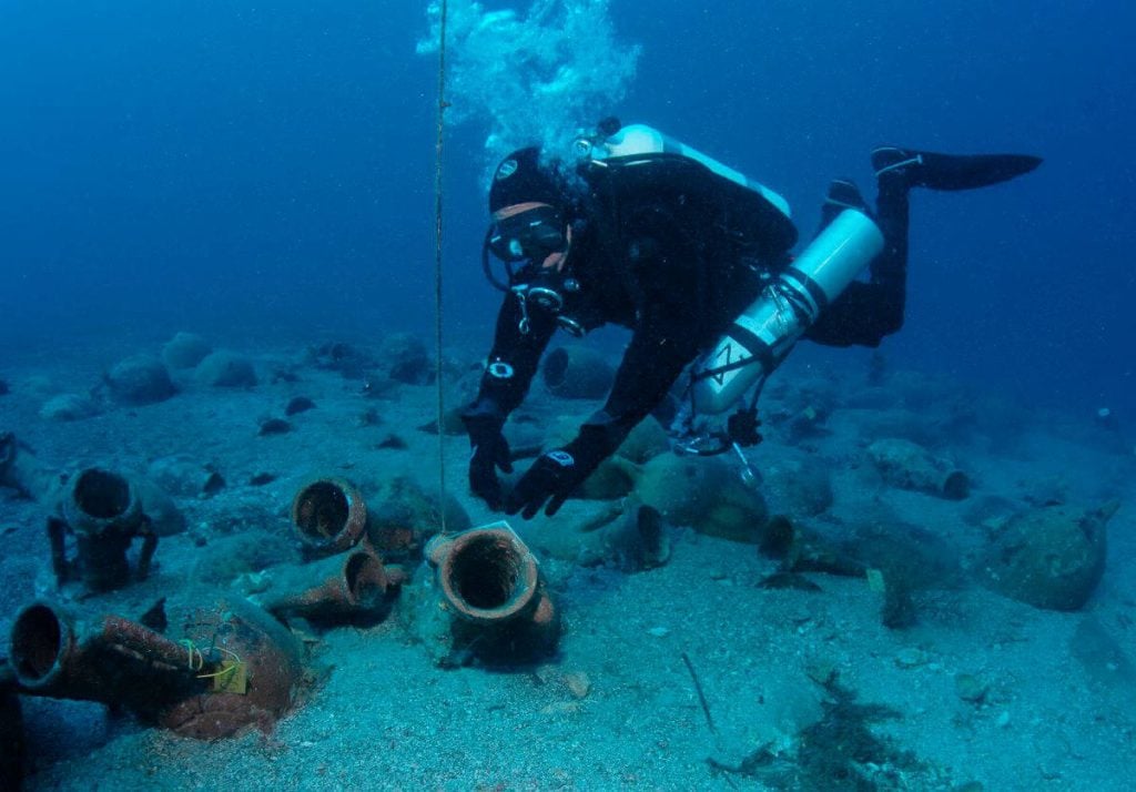 A diver investigates amphorae from a ship that sunk off Kasos island. Photo courtesy of the Kasos Maritime Archaeological Project.
