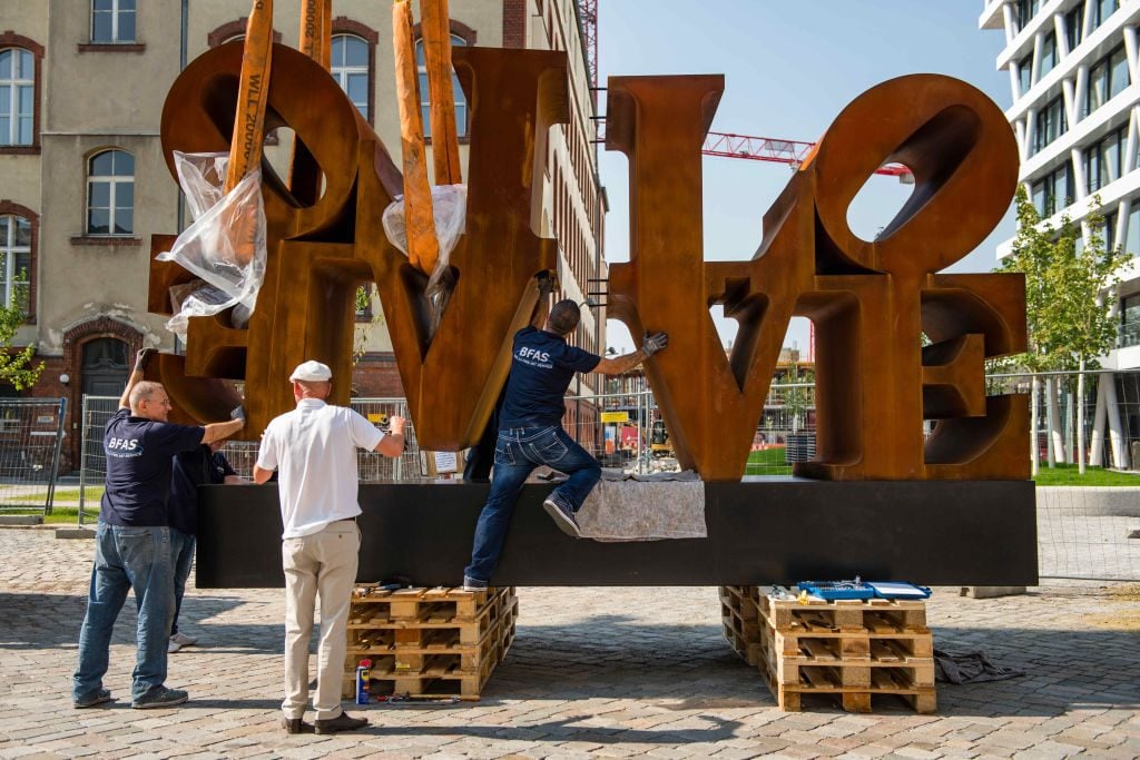 Robert Indiana's 3.5 ton artwork 'Imperial Love' being lifted by a crane at Hamburger Bahnhof museum in Berlin, Germany. Photo by Gregor Fischer/picture alliance via Getty Images.