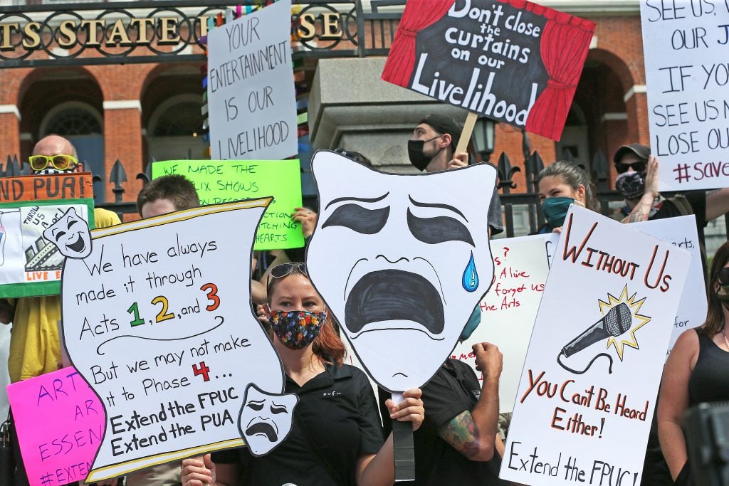 Performance artists rally in front of the the Massachusetts State House in Boston for extended FPUC, the extra $600 provided on top of unemployment during COVID-19 pandemic, on July 20, 2020. Photo by David L. Ryan/the Boston Globe via Getty Images.