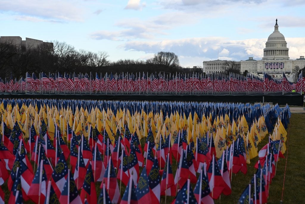Workers work to finish the Field of Flags Art Display along the National Mall. (Photo by Matt McClain/The Washington Post via Getty Images)