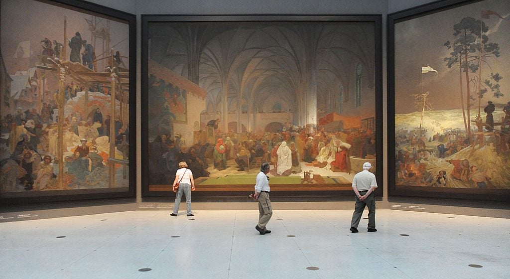 Visitors look at paintings of the "Slav Epic", a cycle of 20 allegories tracing the history of the Slavic people and inspired in part by mythology, by Art Nouveau Czech artist Alfons Mucha, at the National Gallery in Prague. Michal Cizek/AFP/GettyImages.