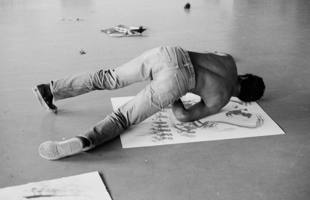 David Hammons inside the Slauson Avenue Studio creating a body print in Los Angeles, 1974. Photo by Bruce W. Talamon, courtesy of the artist.