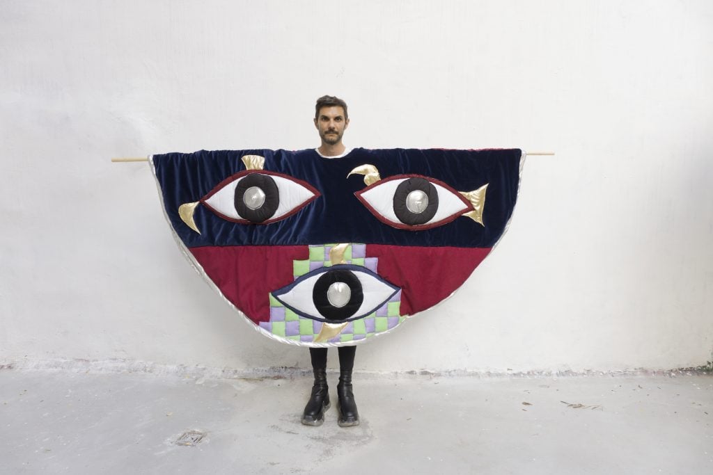The artist Angelo Plessas standing with part of his work The Noospheric Society (2021). Courtesy the artist.