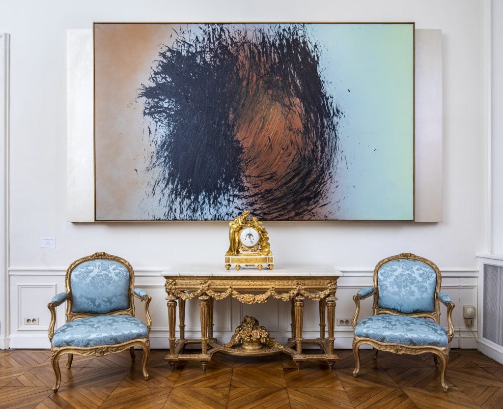 Installation view with Hans Hartung's T 1982-E 16(1982) with a Louis XVI clock and console table and Louis XV giltwood armchairs stamped by J-J.Pothier. Courtesy of Kraemer Gallery.