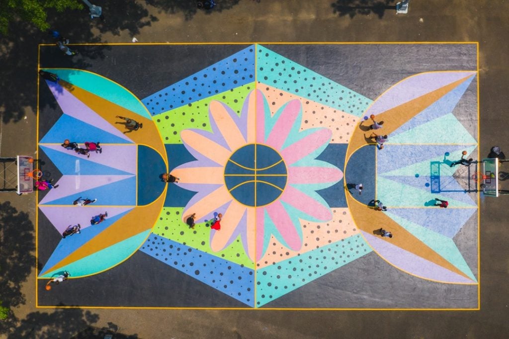 In 2019, Facebook Open Arts supported artist Saya Woolfalk and local youth group Publicolor in their creation of a basketball court mural in Marcus Garvey Park in Harlem. Photo courtesy Facebook.