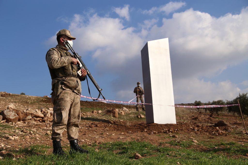 Soldiers stand guard near a monolith, triangular in shape and metallic in composition, appeared at the ancient site of Gobeklitepe, known as the world's oldest temple, in Sanliurfa, Turkey on February 06, 2021. Photo by Yasin Dikme/Anadolu Agency via Getty Images.