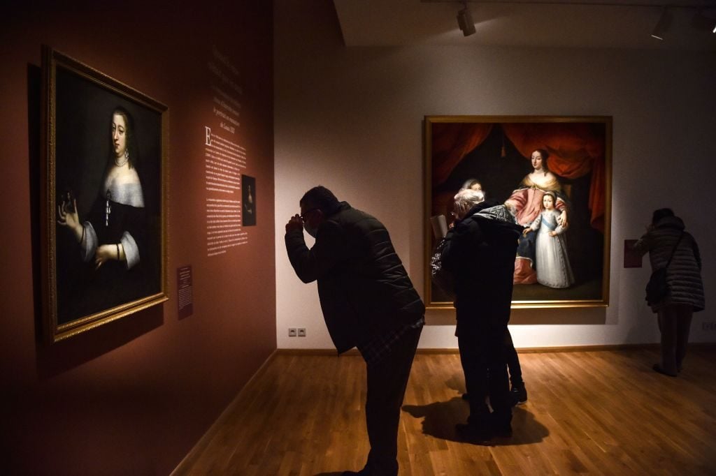 People visit the exhibition "Portraits de reines de France" at the Hyacinthe-Rigaud art museum in Perpignan on February 9, 2021. Photo: Raymond Roig / AFP via Getty Images.
